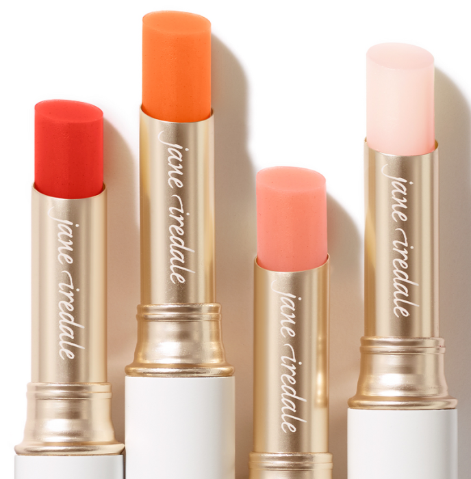 Na-zdjeciu-cztery-pomadki-ochronne-marki-Jane-Iredale-w-sztyfcie.-Kazda-z-nich-ma-inny-odcien-intensywnie-czerwony,-energetyczny-pomaranczowy,-delikatny-brzoskwiniowy-i-przezroczysty-rozowy.-Opakowania-sa-eleganck.webp